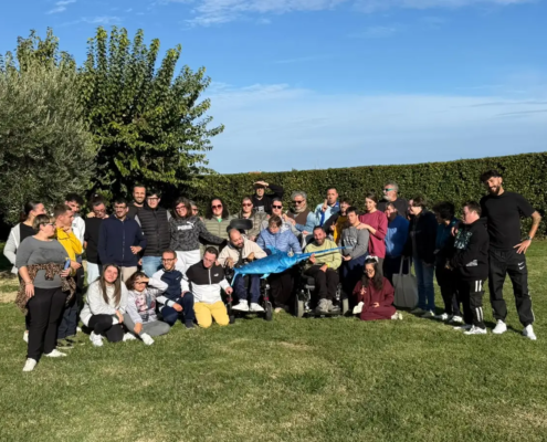 L'artista Ravel e i ragazzi della fattoria sociale Rurabilandia posano insieme alla scultura di pesce spada SPA-DINO realizzata con materiali di recupero.