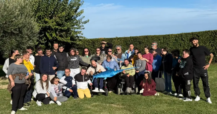 L'artista Ravel e i ragazzi della fattoria sociale Rurabilandia posano insieme alla scultura di pesce spada SPA-DINO realizzata con materiali di recupero.